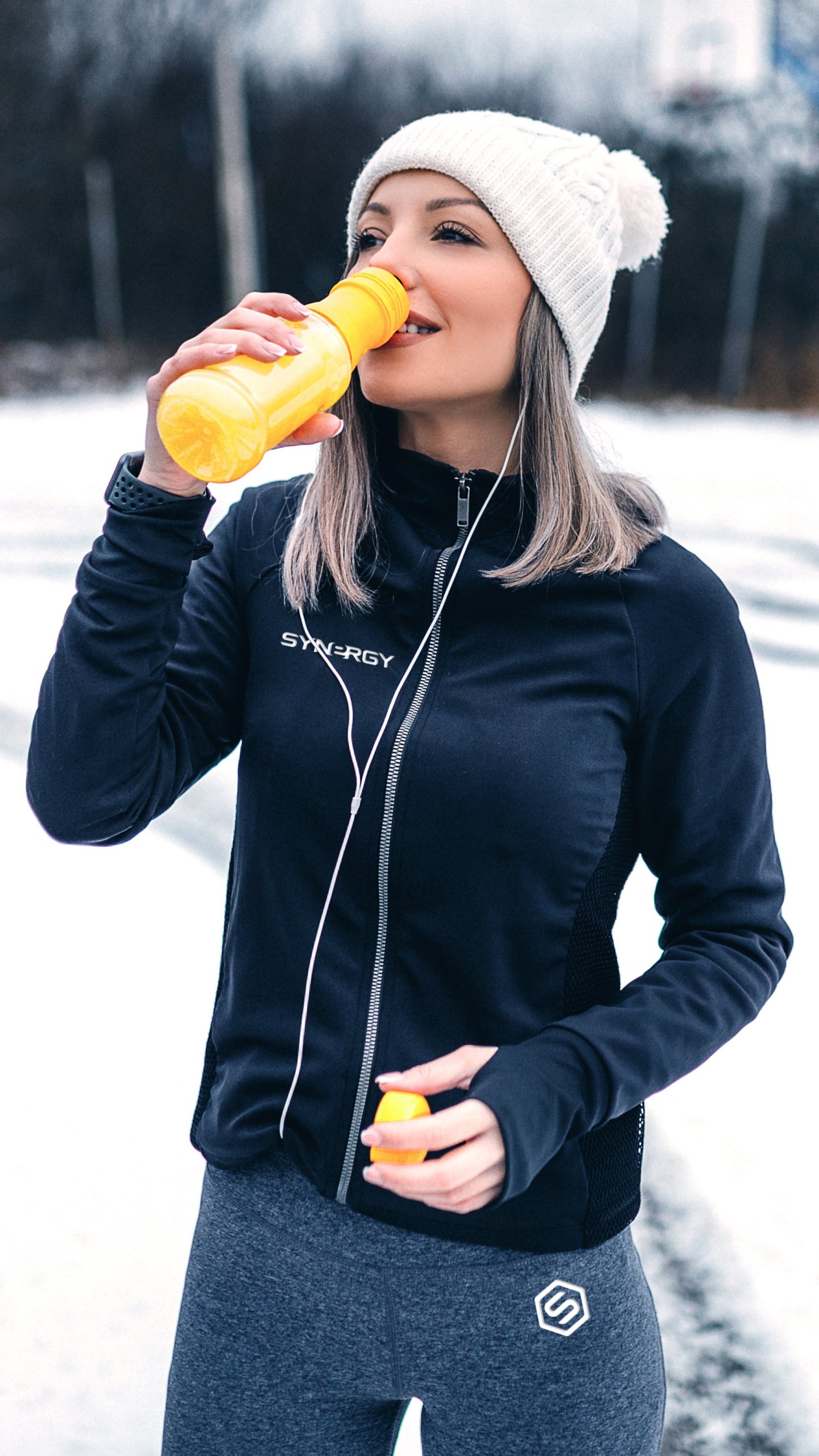 Hyvinvoiva nainen juo pullosta lisäravinteita